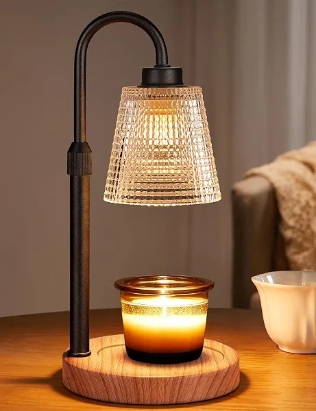 Innqoo candle warmer lamp lit, warming a scented candle with a warm glow on a wooden base