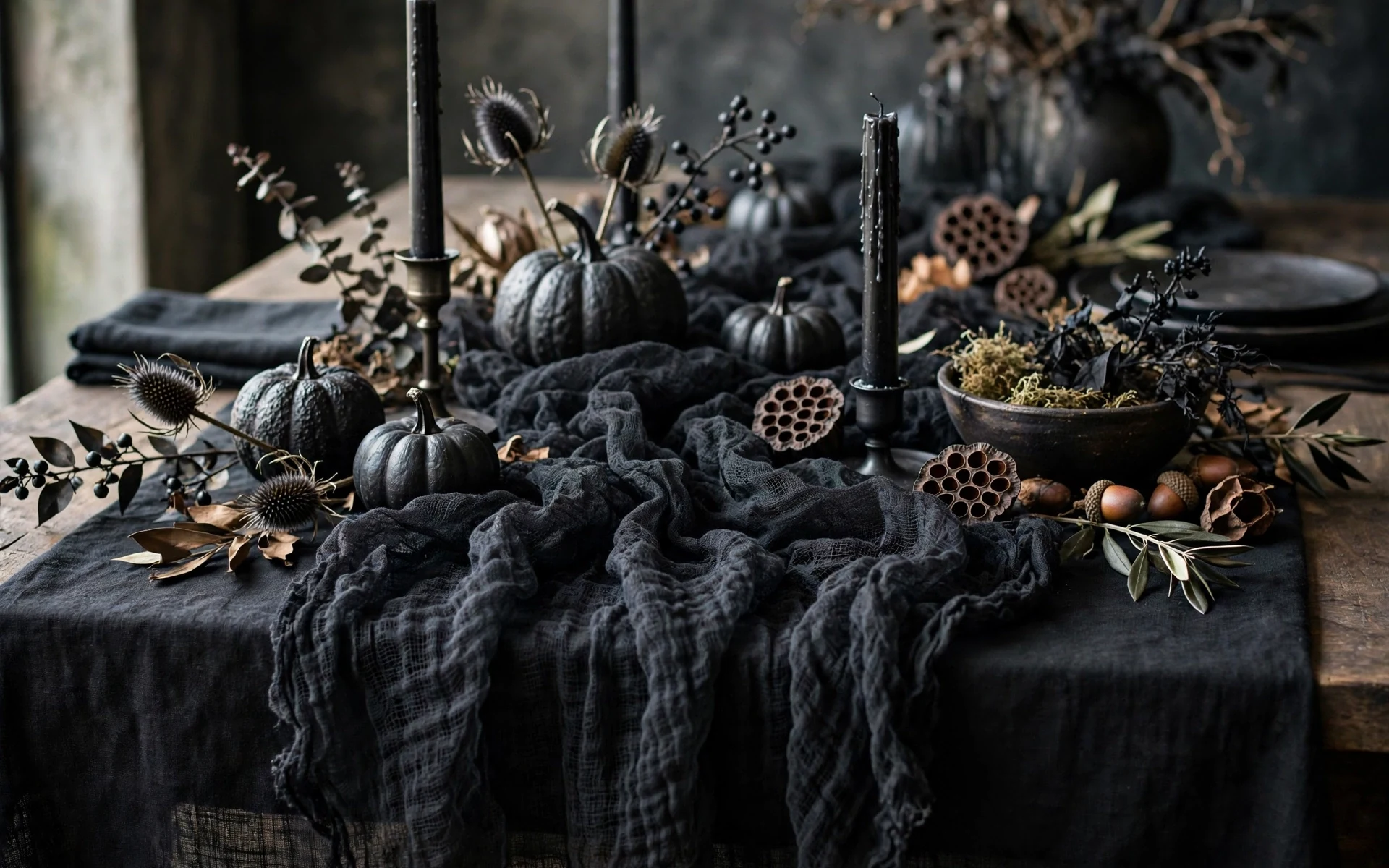Gauze runner halloween table setting ideas layered over a black tablecloth