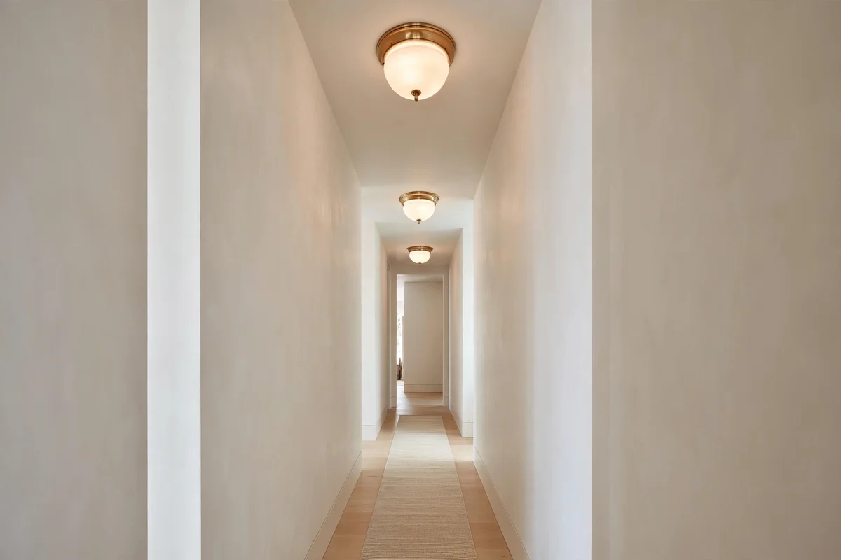 Narrow hallway decorating ideas: narrow hallway painted warm white with eggshell finish and evenly spaced ceiling lights